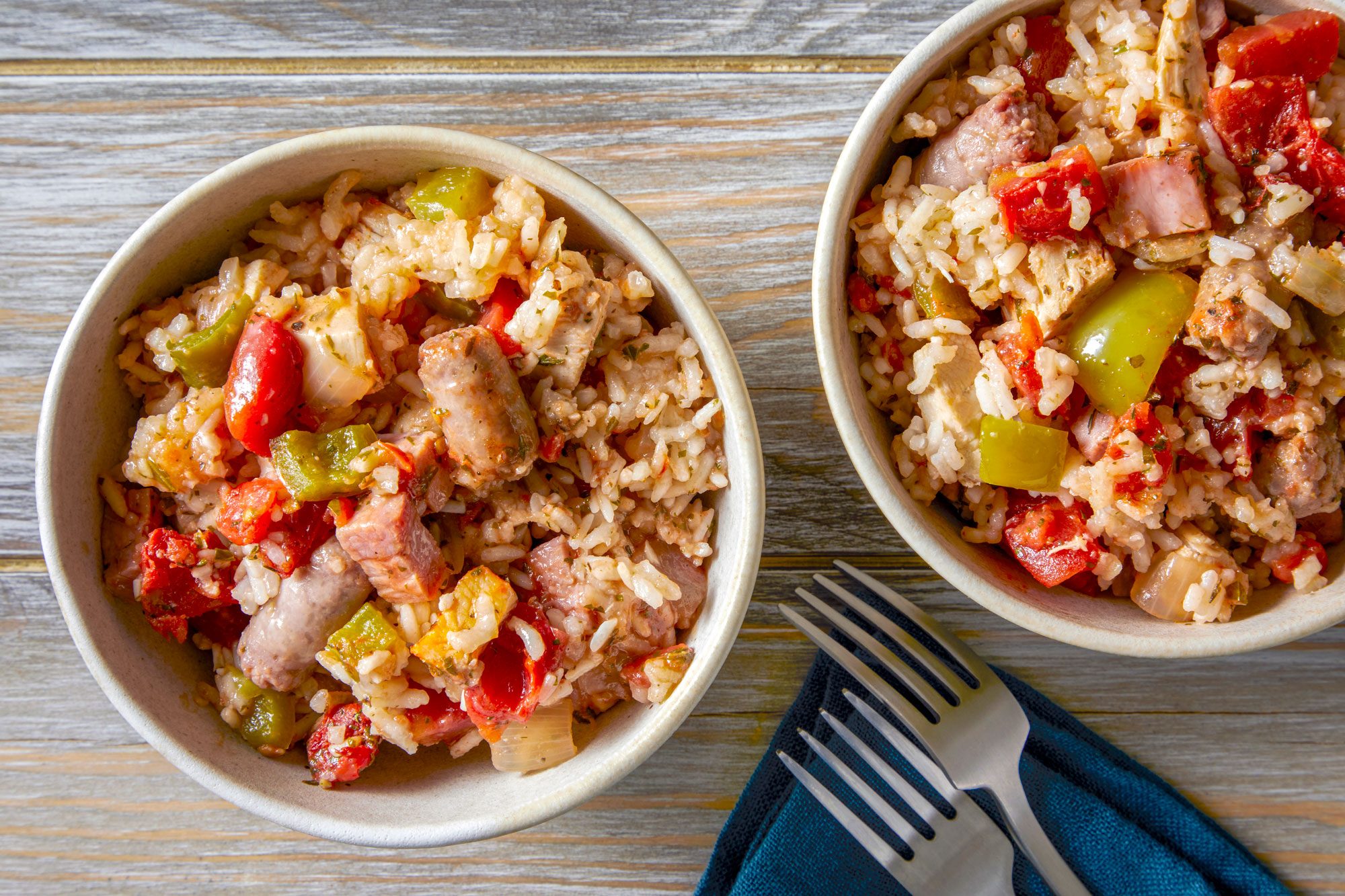 Sausage Jambalaya served in two bowls with fork and napkin