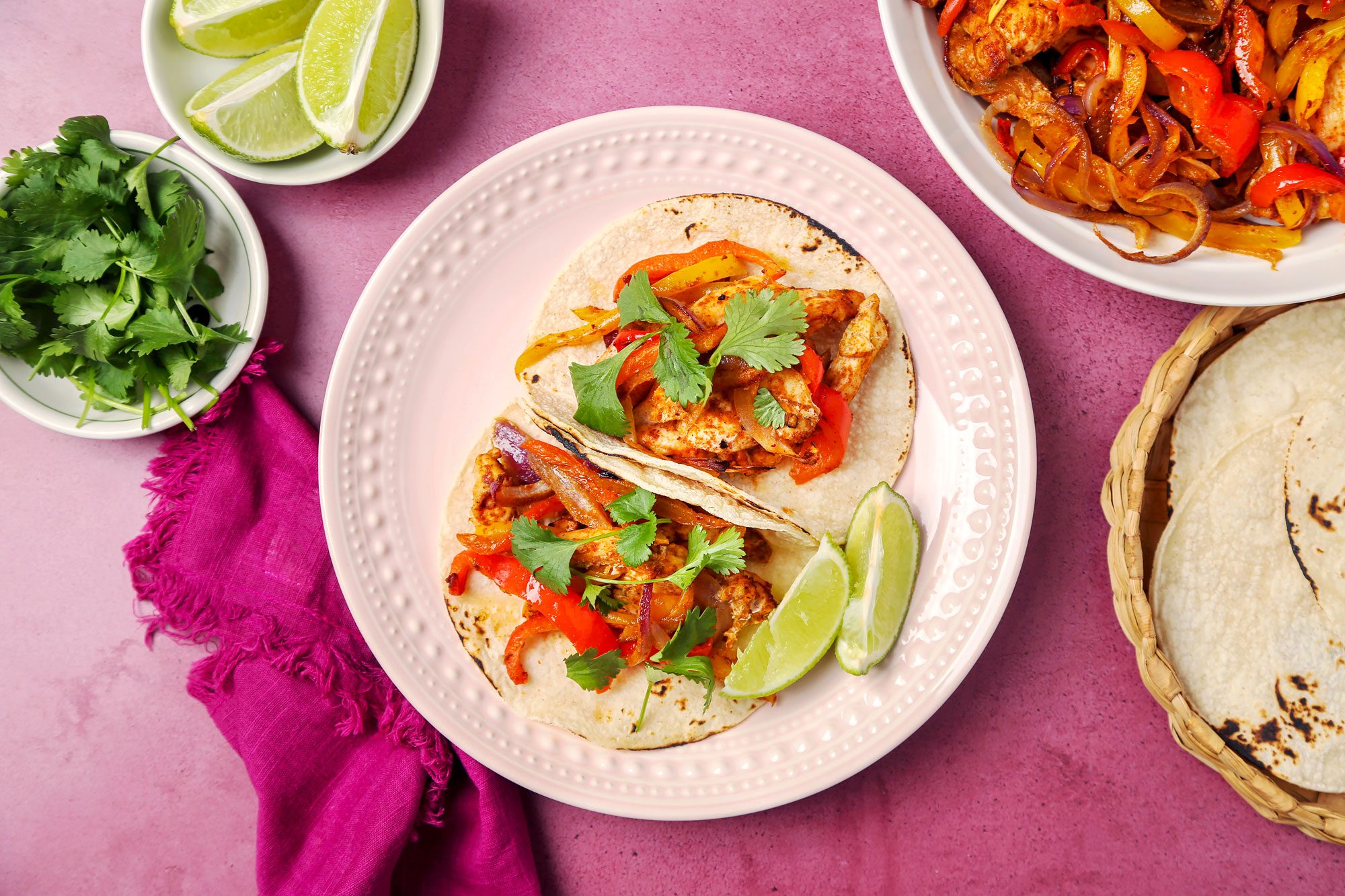 Chicken Fajitas served on tortillas on a pink plate; overhead