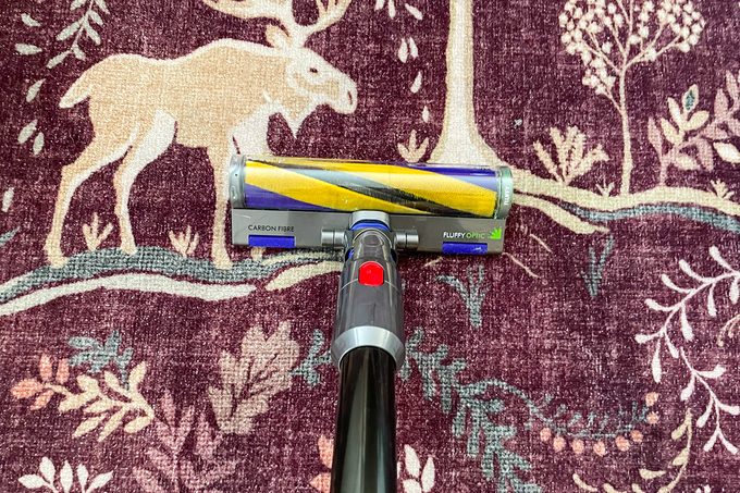 A vacuum cleaner cleaning a rug.