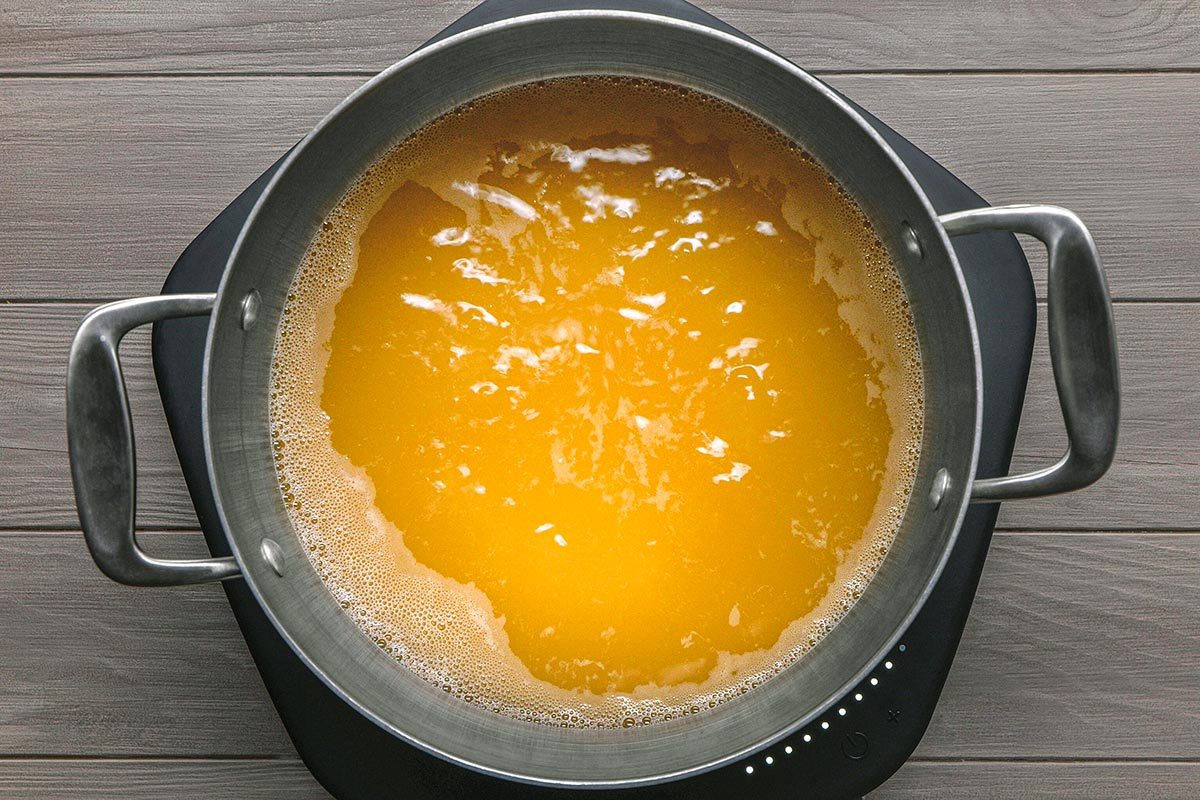 Chicken broth being heated in a large saucepan