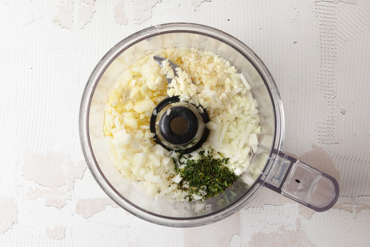 onion, garlic, oregano and olive oil in a food processor 