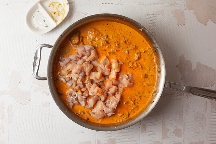 chicken added to tomato paste and onion mixture in pan