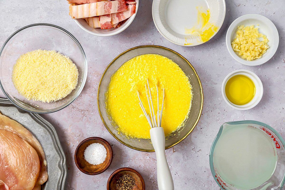 overhead shot of a bowl contains a bright yellow mixture that appears to be whisked