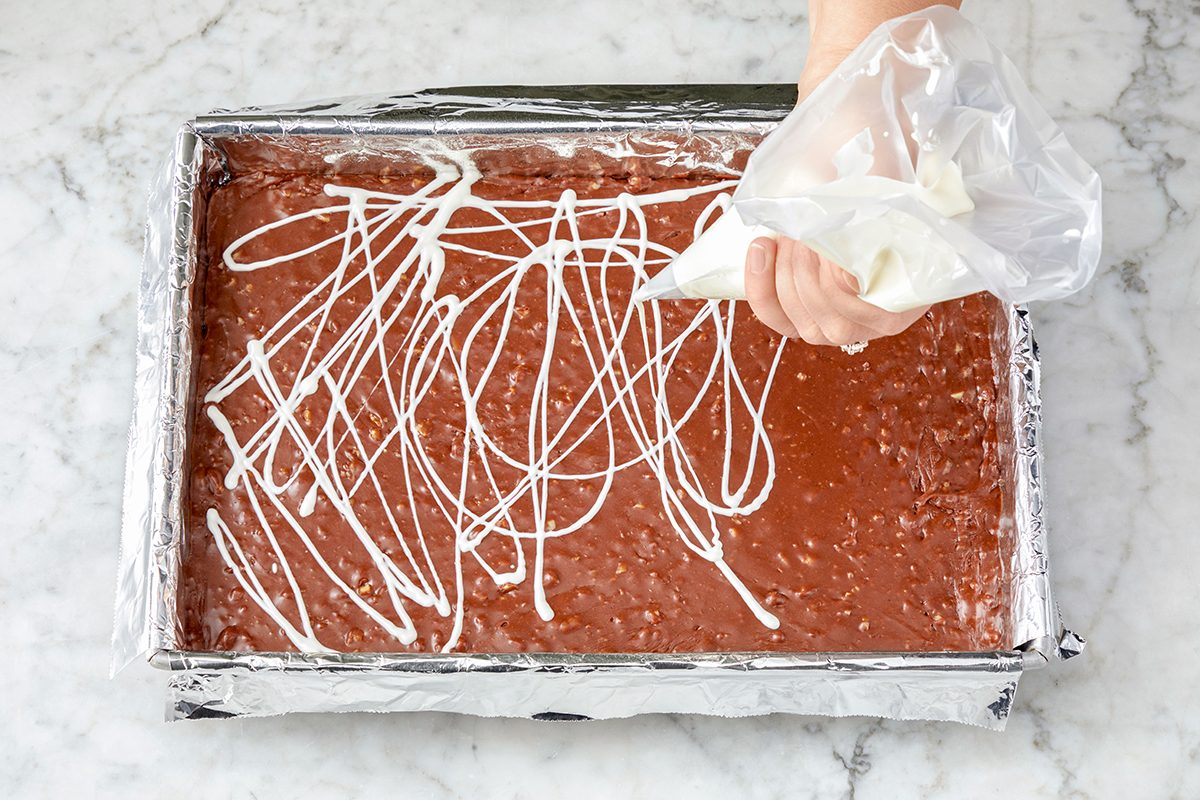 White chocolte drizzling on a chocolate mixture