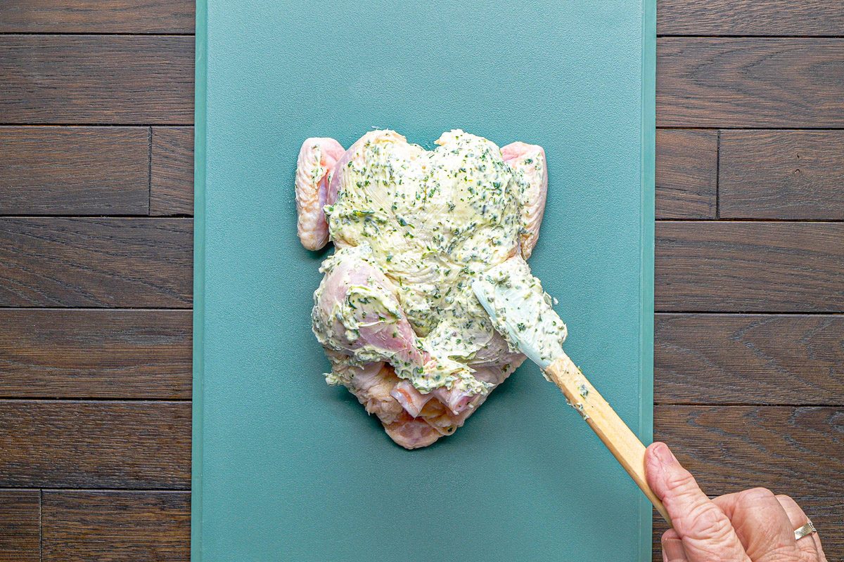 rubbing butter mixture over hen's skin