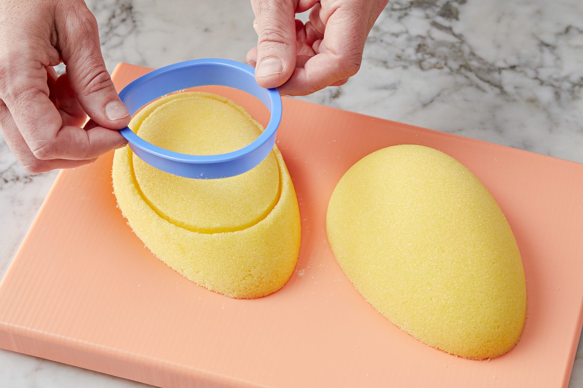 egg-shaped cookie cutter being pressed into a sugar egg
