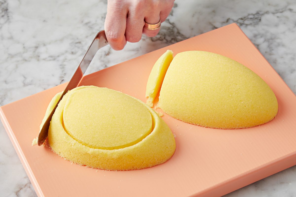 small portion from the large bottom end of an egg half being trimmed with an offset spatula