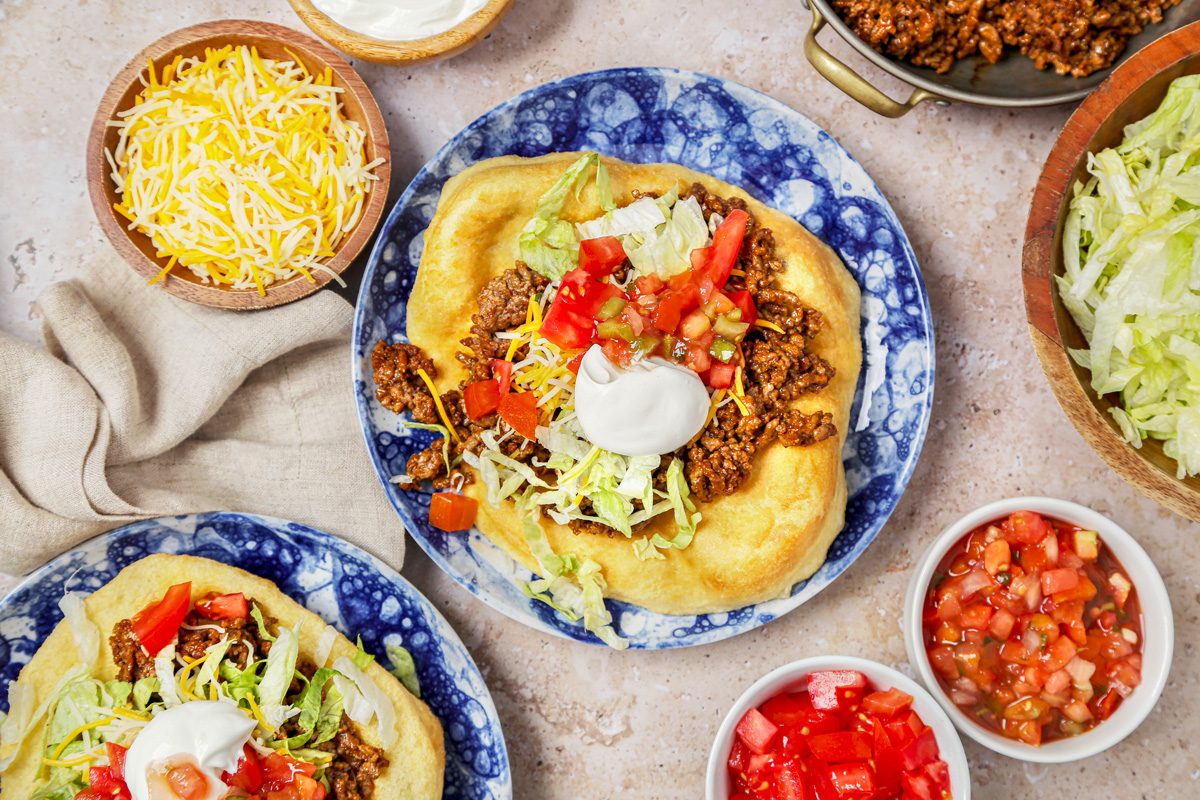 Fry bread tacos served with salsa and sour cream.