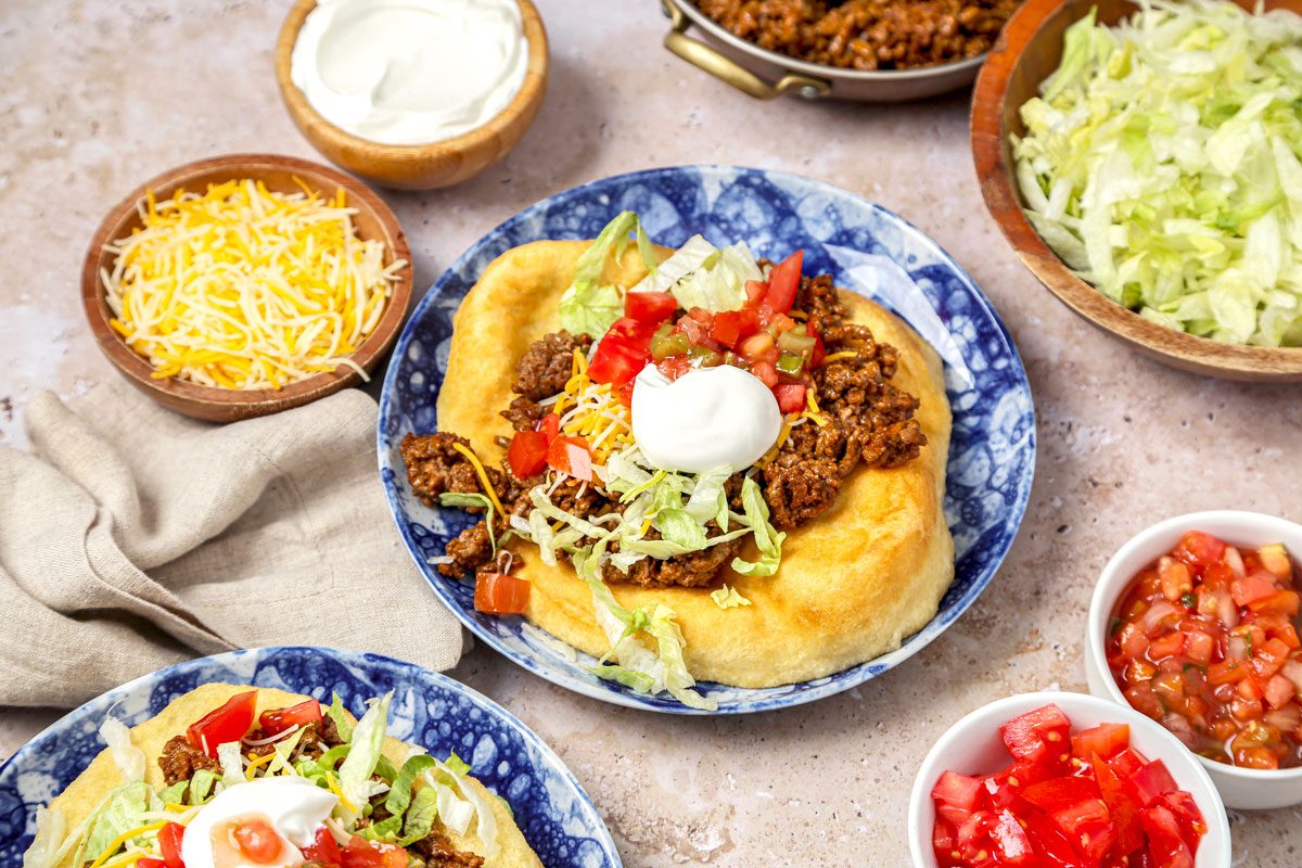 Fry bread tacos served with salsa and sour cream.