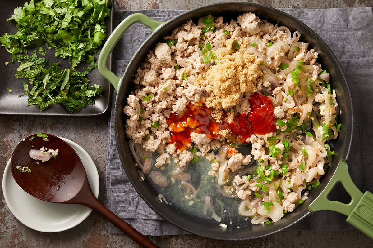 Stir in the cooked chicken, lime juice, fish sauce, chili sauce, brown sugar and Sriracha