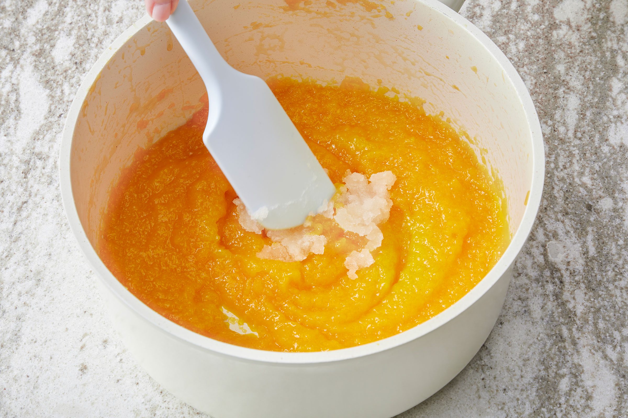 Stirring the bloomed gelatin into the mango mixture