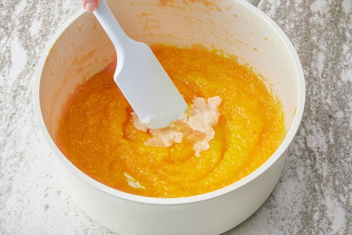 Stirring the bloomed gelatin into the mango mixture