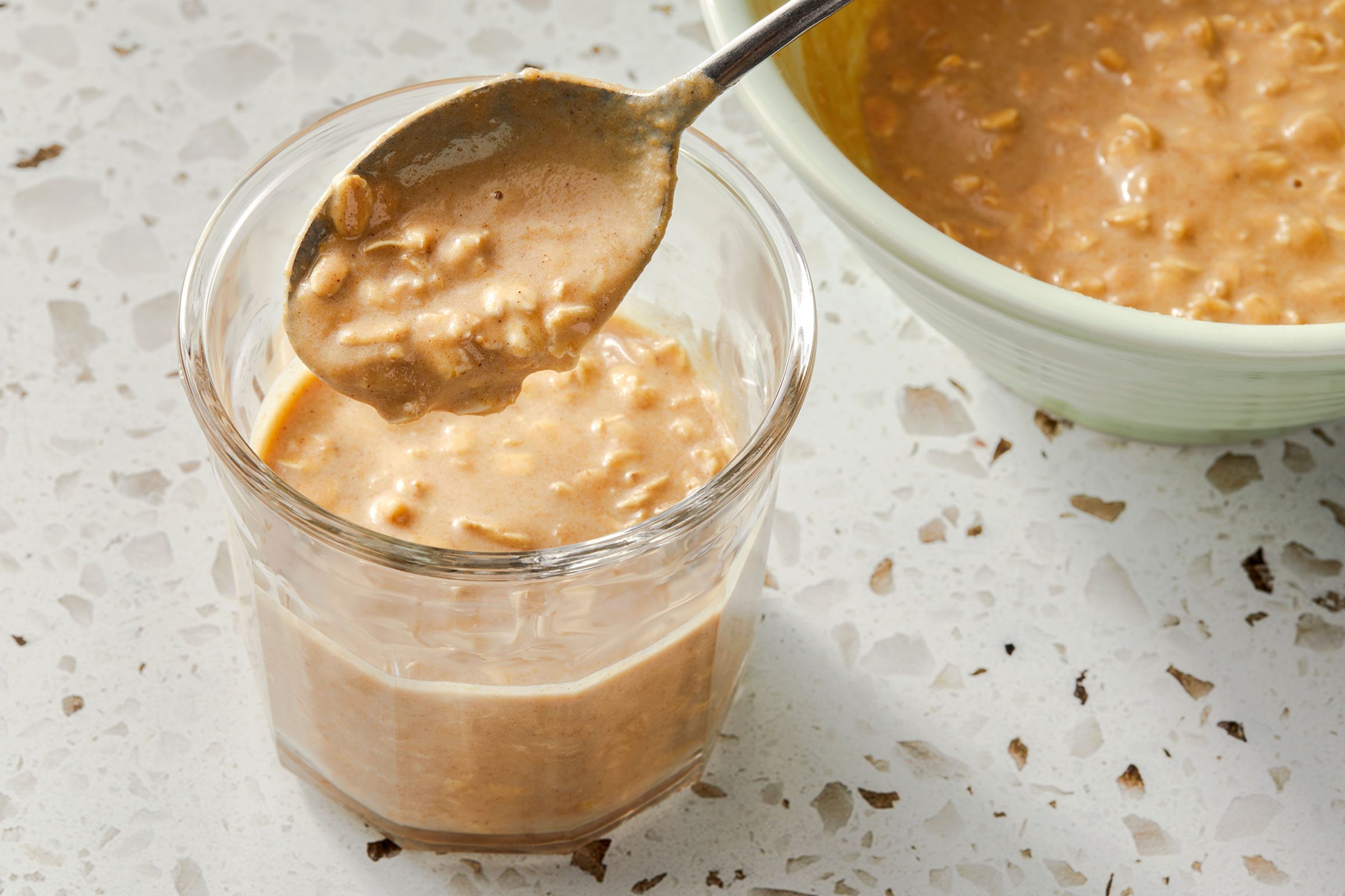 Oatmeal mixture poured into a glass with a spoon