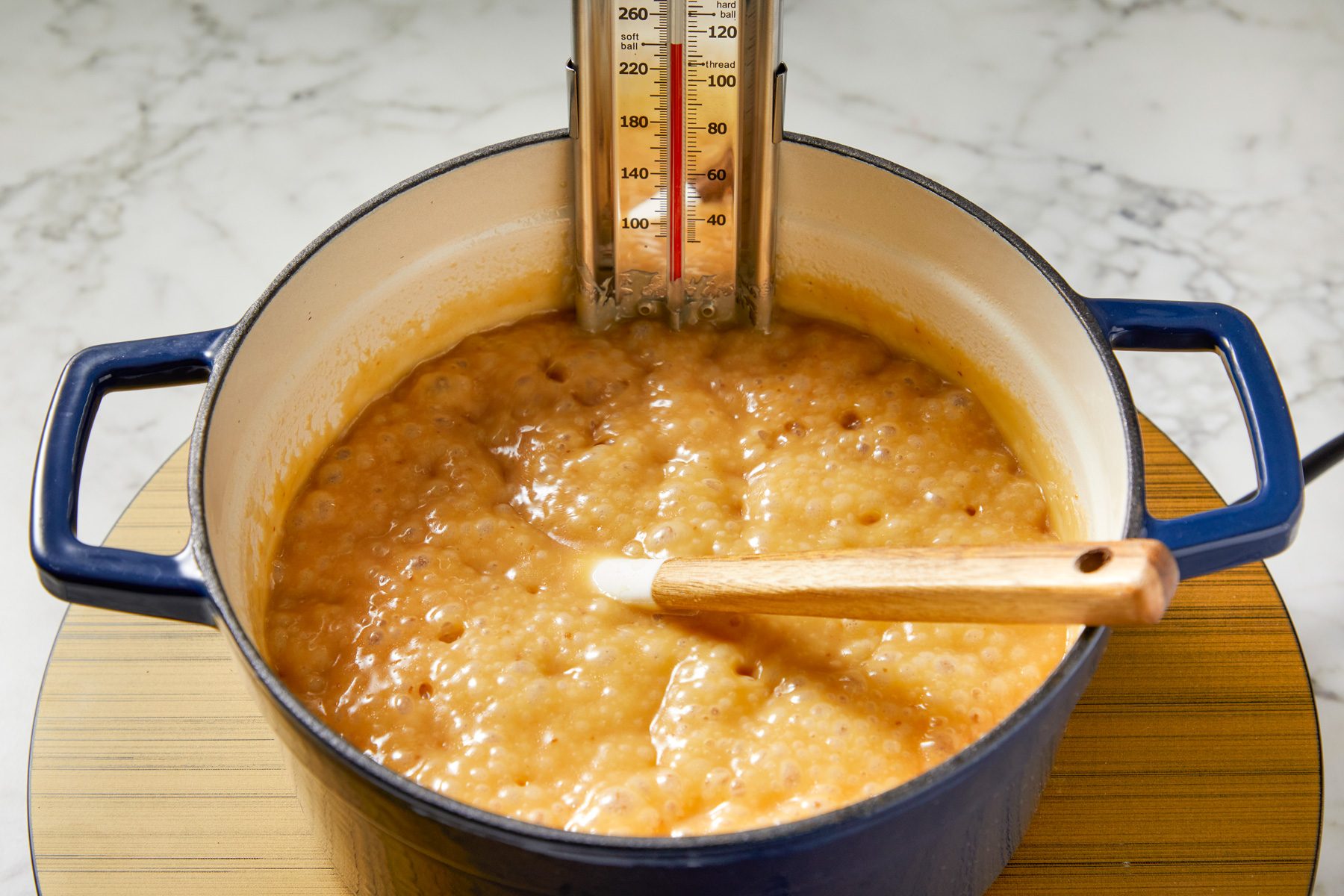 Close shot of Cook; stirring occasionally; until a candy thermometer reads 236 degree (soft-ball stage) about 20 minutes; spatula; marble surface;
