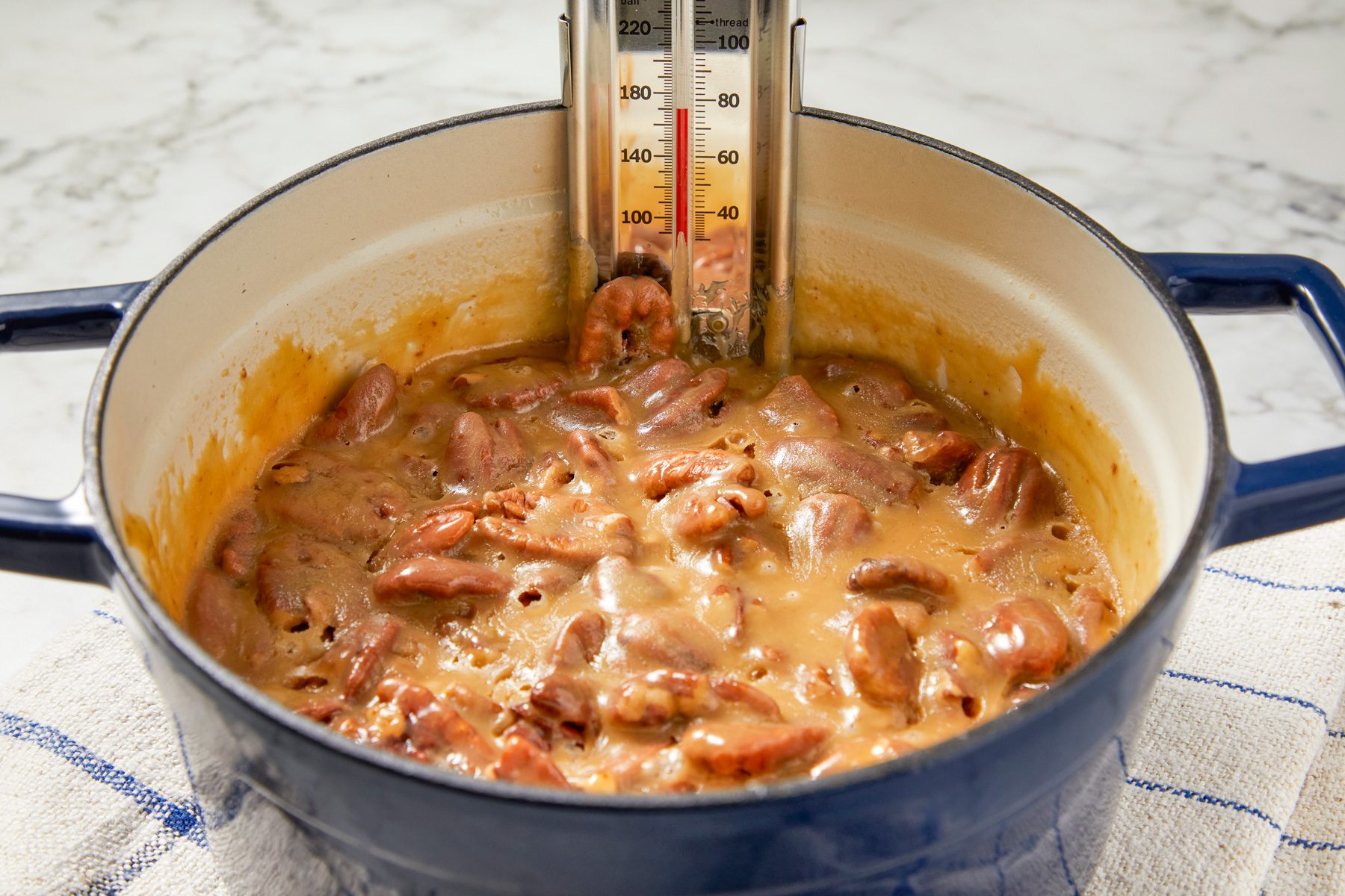 Close shot; Stir with a wooden spoon until mixture just begins to thicken but is still glossy about 2 minutes; napkin; marble surface;