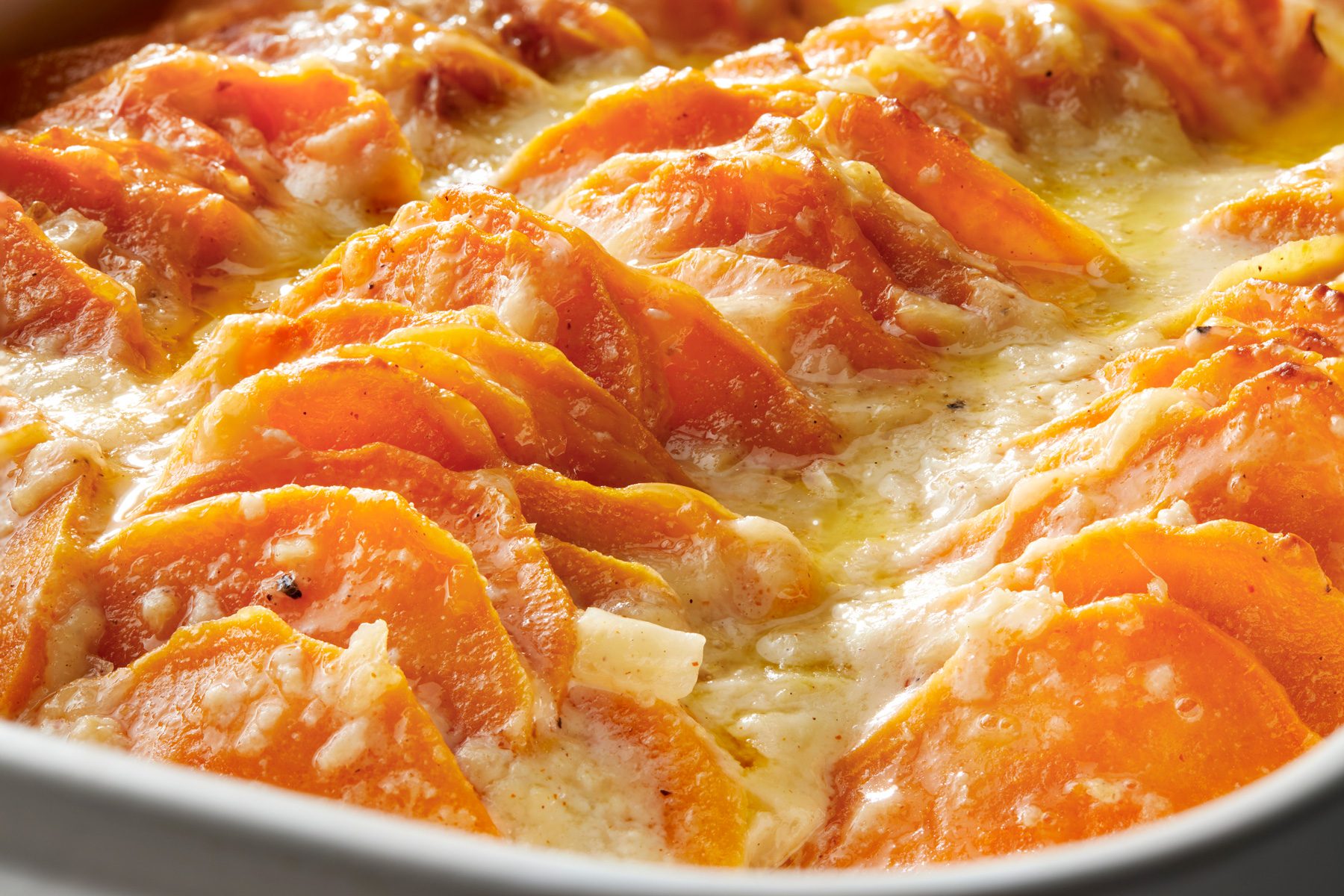 Close up shot of Savory Scalloped Sweet Potatoes; in a baking pan;