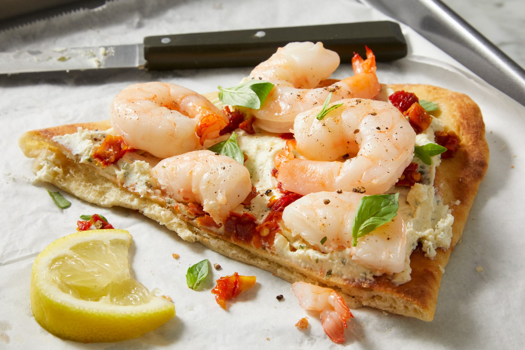 closeup shot of Speedy Shrimp Flatbreads, a wedge of lemon sits beside the flatbread
