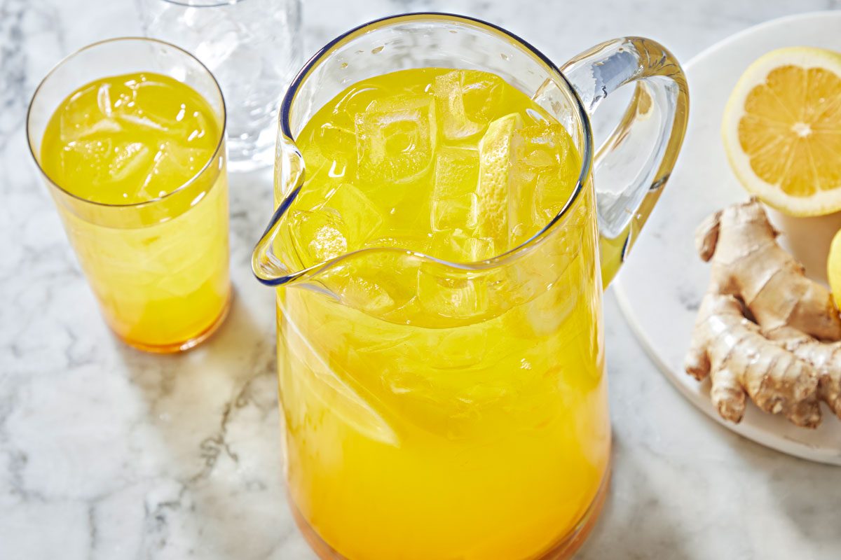 Turmeric Water in a jug with filled glass on a table, ready to serve