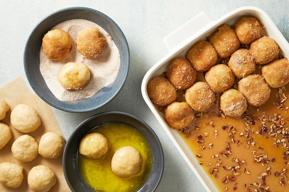 Overhead shot; Pour melted butter into a shallow bowl; In another shallow bowl mix sugar and cinnamon; Punch down dough; Turn onto a lightly floured surface; divide and shape into 48 balls