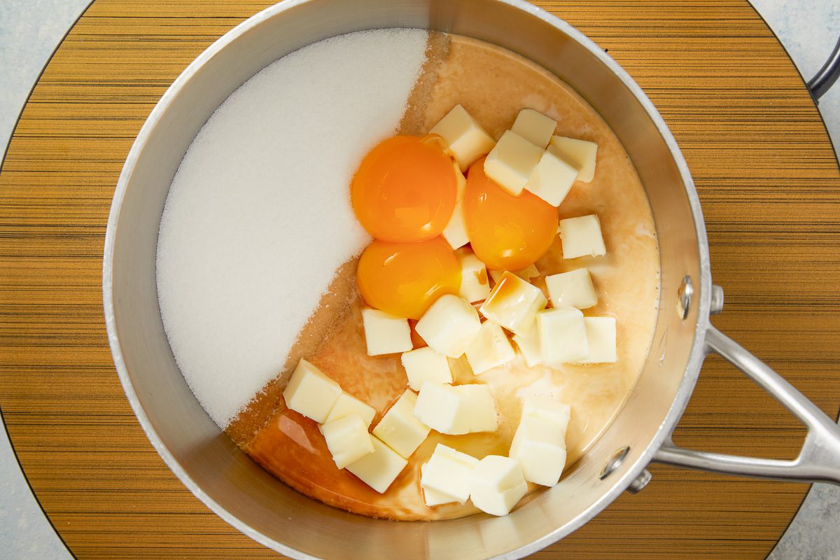 milk, sugar, egg yolks, butter and vanilla whisked together in a pan