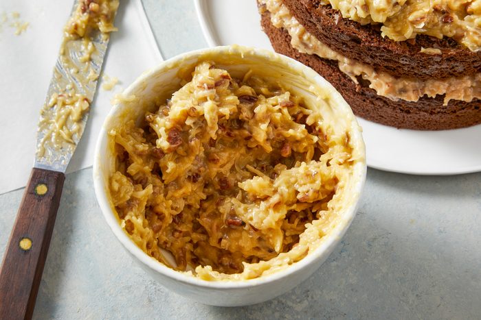 Coconut Pecan Frosting in a bowl next to cake