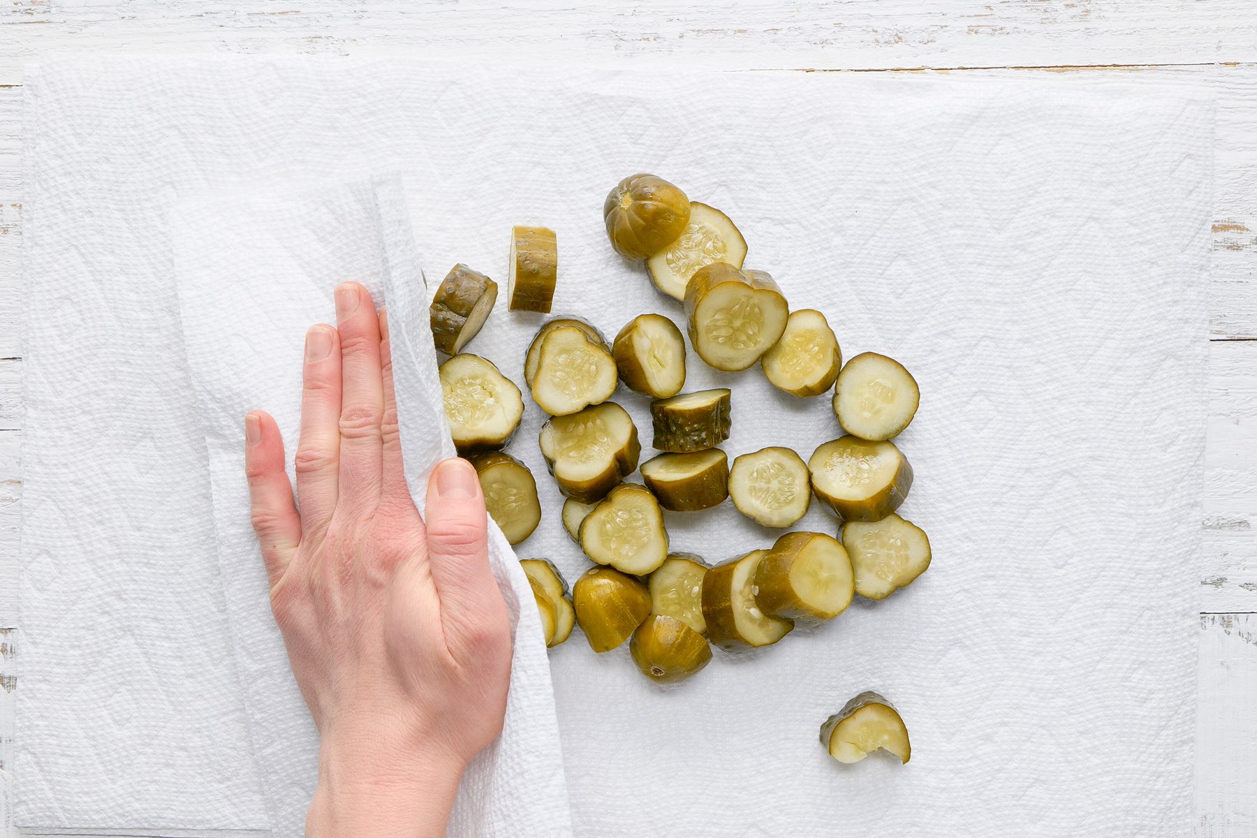 Overhead shot of drain on paper towels; blot with additional paper towels until dry; white wooden surface;