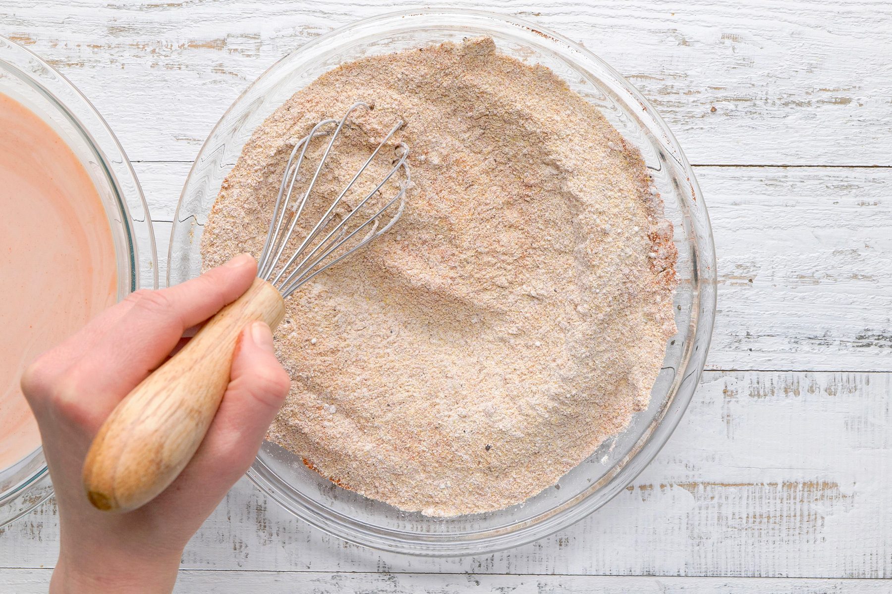 Overhead shot; In another shallow bowl; mix flour; cornmeal; garlic salt; paprika; cayenne pepper and pepper; white wooden surface;