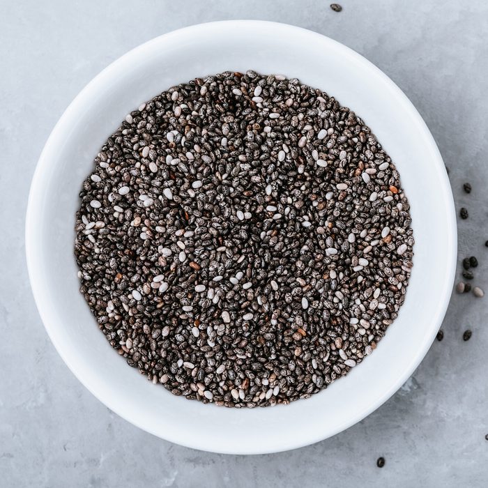 Chia seeds. Organic Dry Black and White Chia Seeds in bowl on gray stone background.