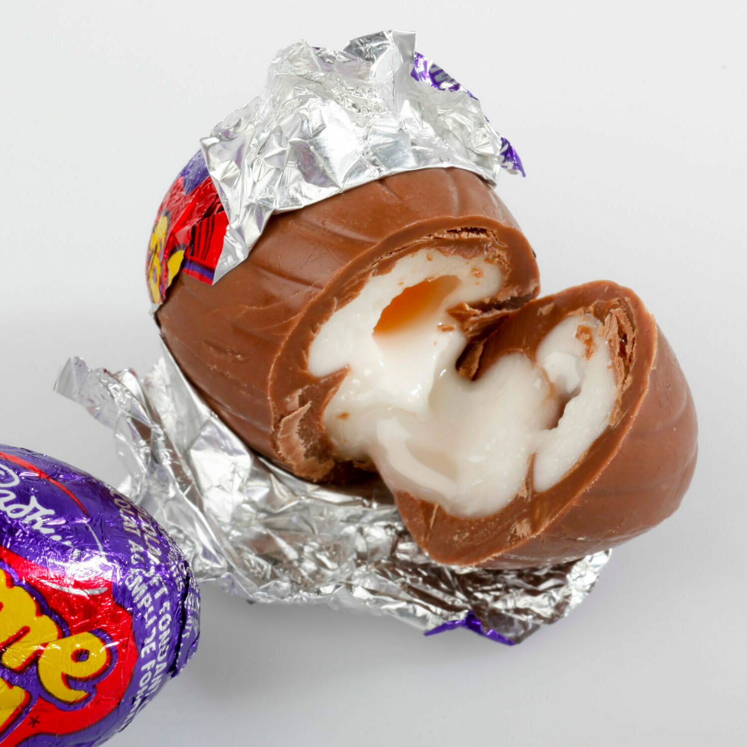 Opened and cut cadbury creme egg on a white background