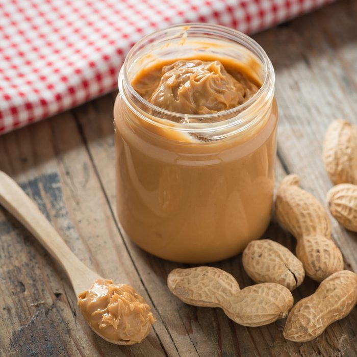 Creamy peanut butter on wood table. Selective focus.