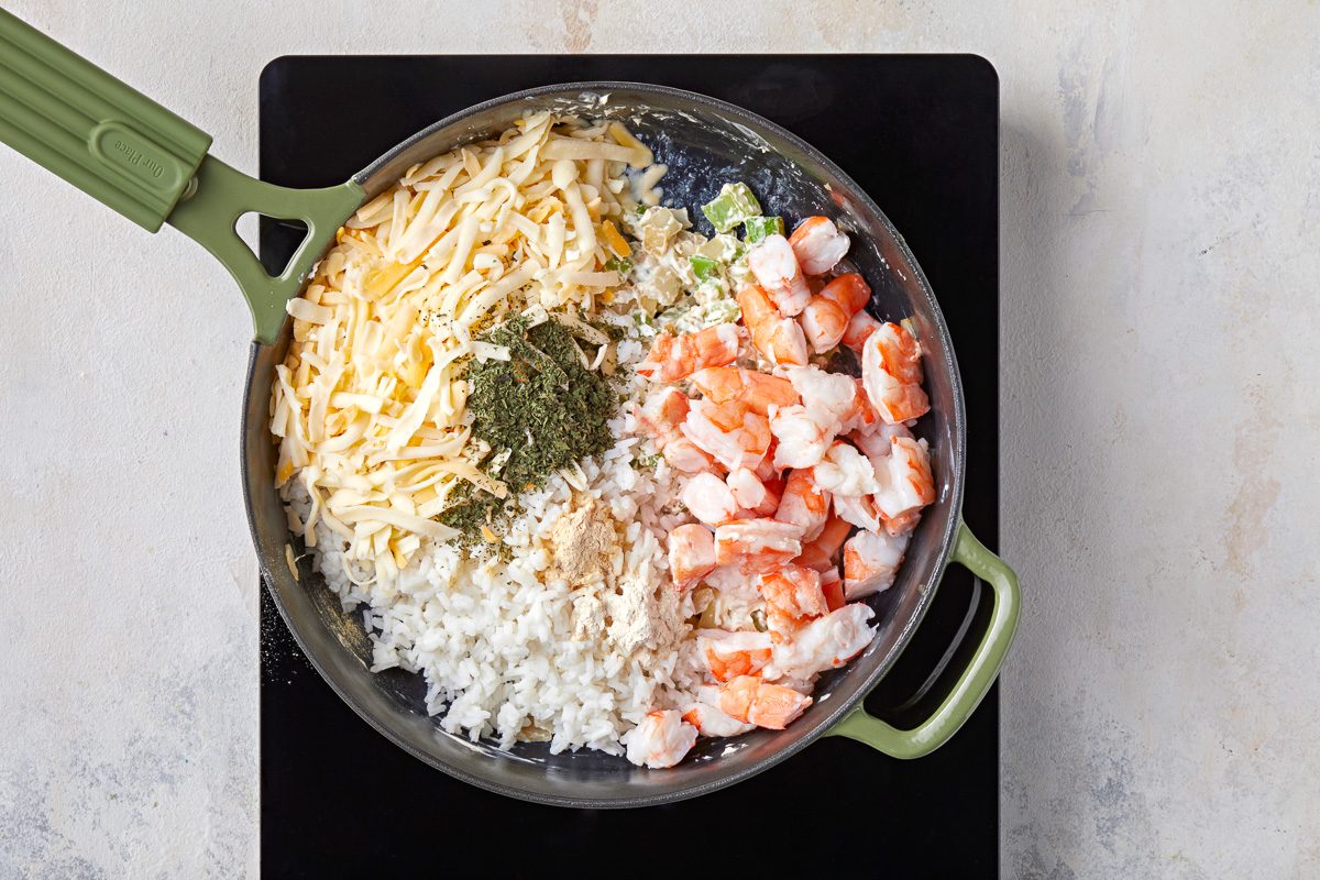 cooked shrimp, cheese blend, cooked rice, lemon juice, cilantro, onion powder and garlic powder added to skillet with sautéed onions and celery