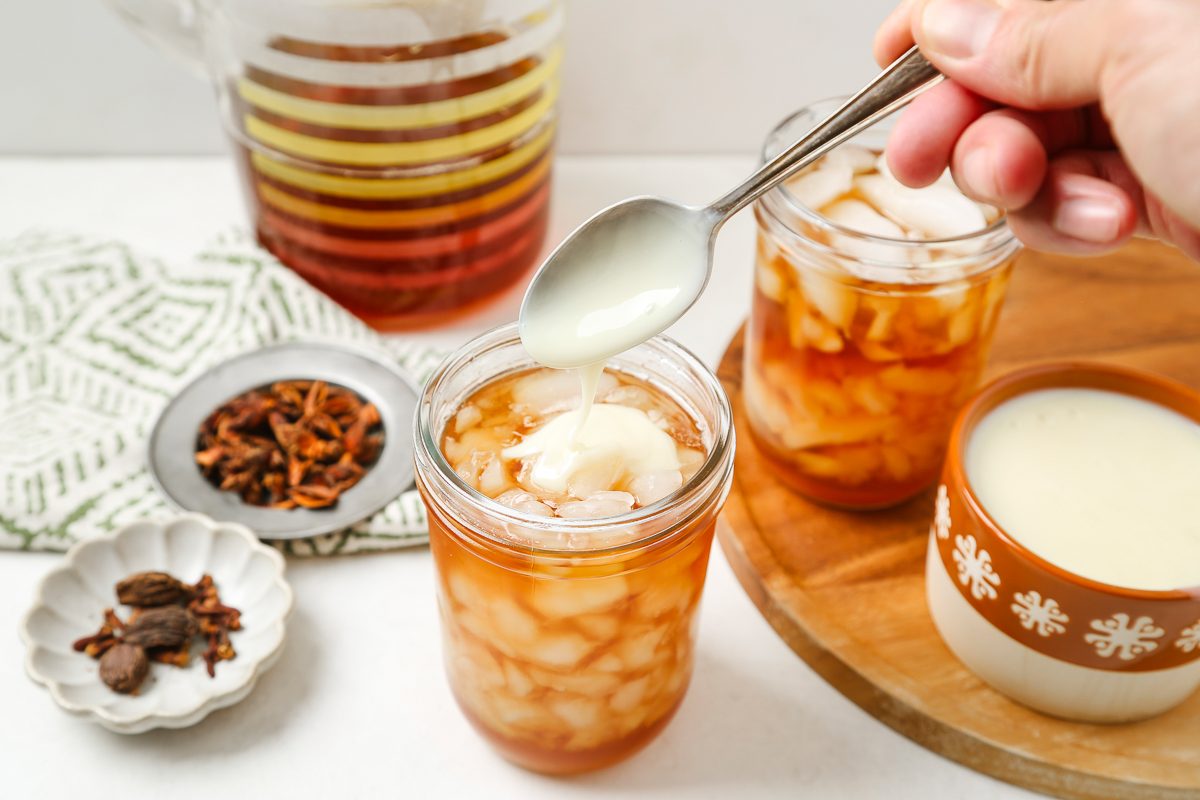 topping glasses of tea with sweetened condensed milk