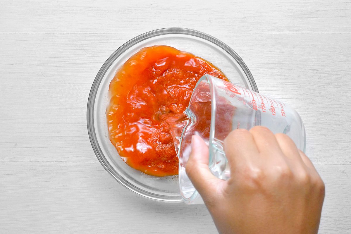 overhead shot of a glass bowl filled with a red sauce