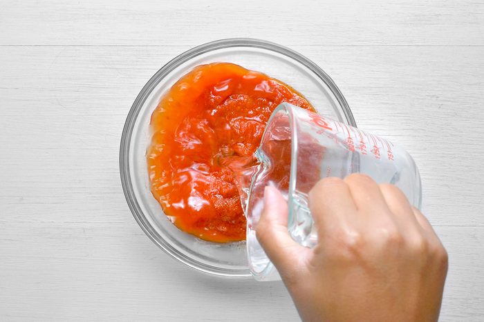 overhead shot of a glass bowl filled with a red sauce