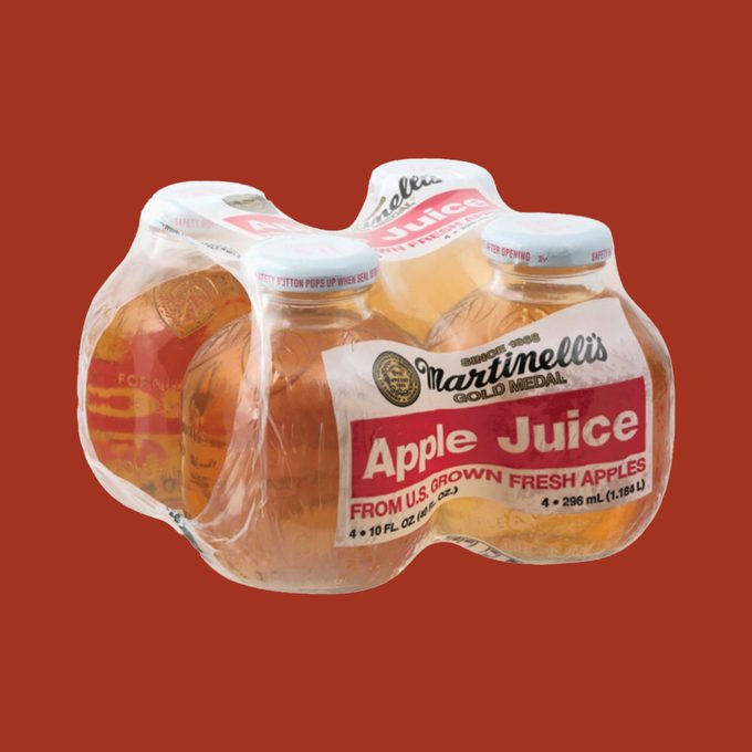 4-pack of Martinellis apple juice wrapped in plastic on red background