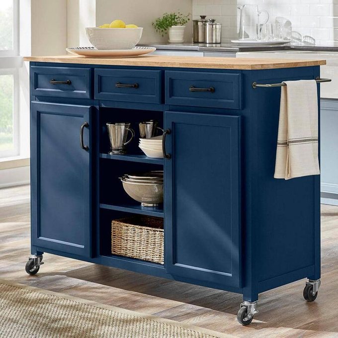 Home depot blue moveable kitchen island styled with various kitchen products on shelves and counter