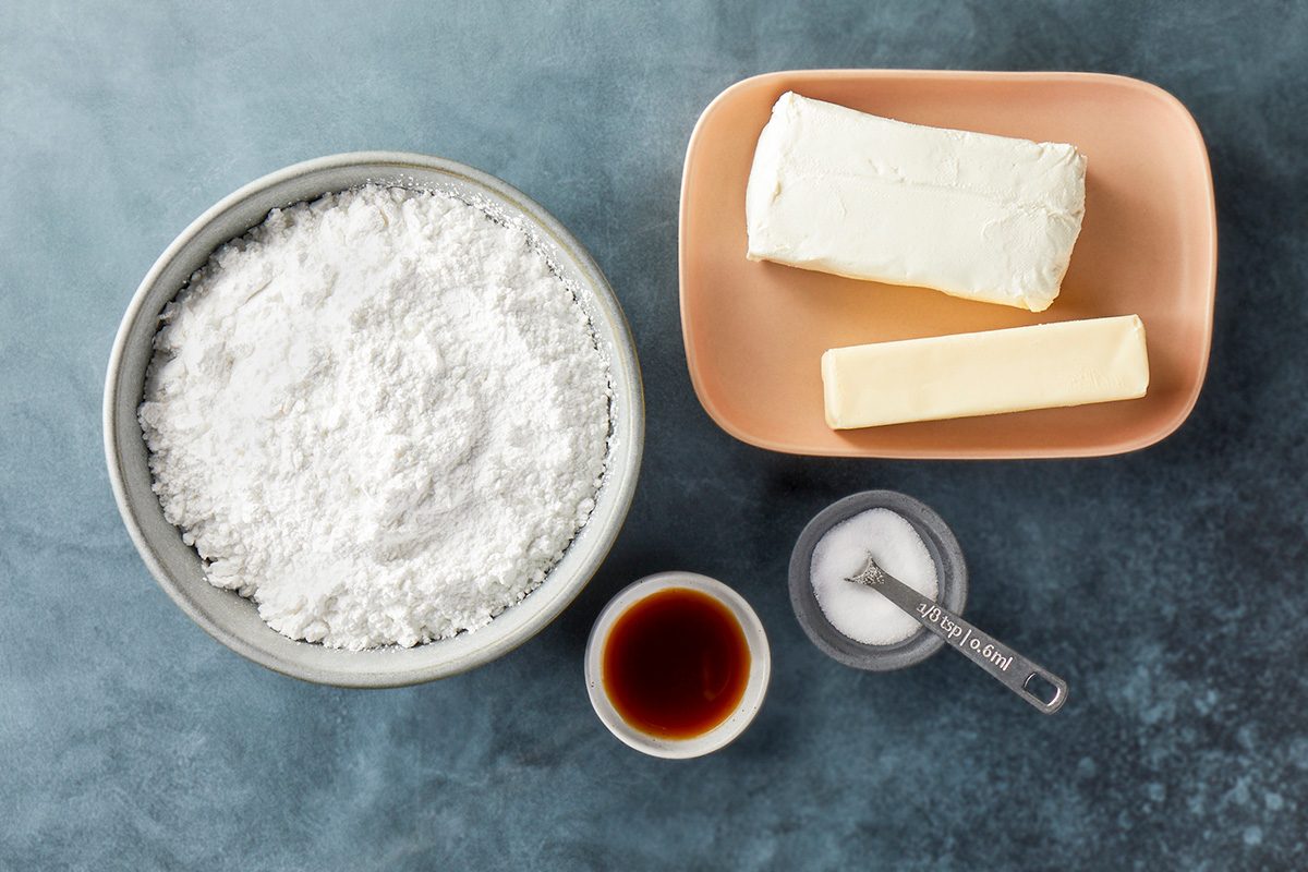 overhead shot of Cream Cheese Frosting ingredients placed over dark gray background