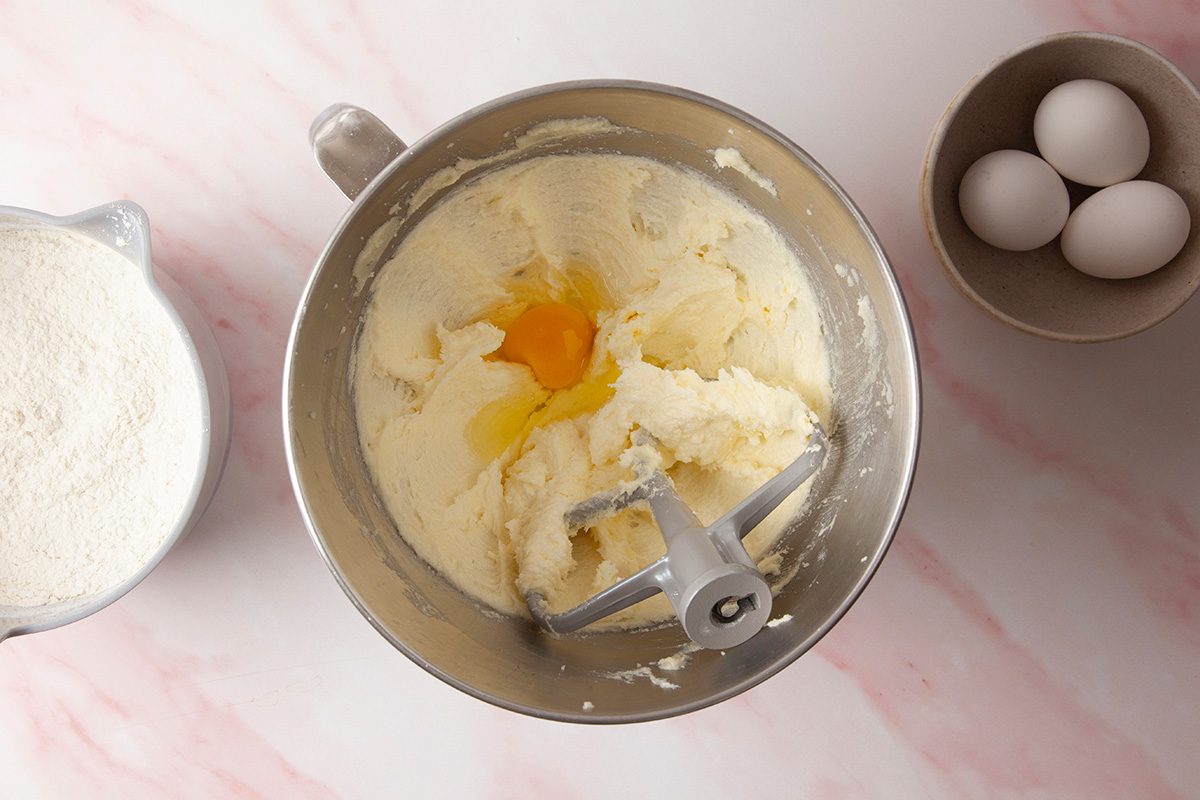 In a large bowl whisk together flour; baking powder; salt and in another bowl mix cream butter; sugar and add eggs one at a time mixing well after each addition