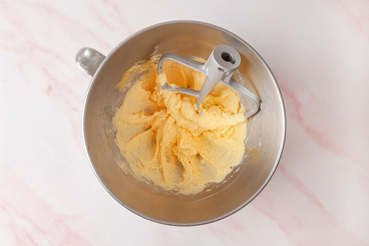egg yolks and granulated sugar being beated in a large bowl
