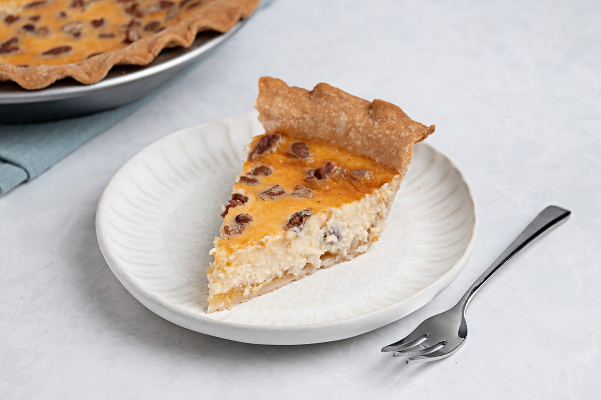 Pineapple Cream Cheese Pie slice on a white plate with a fork next to it