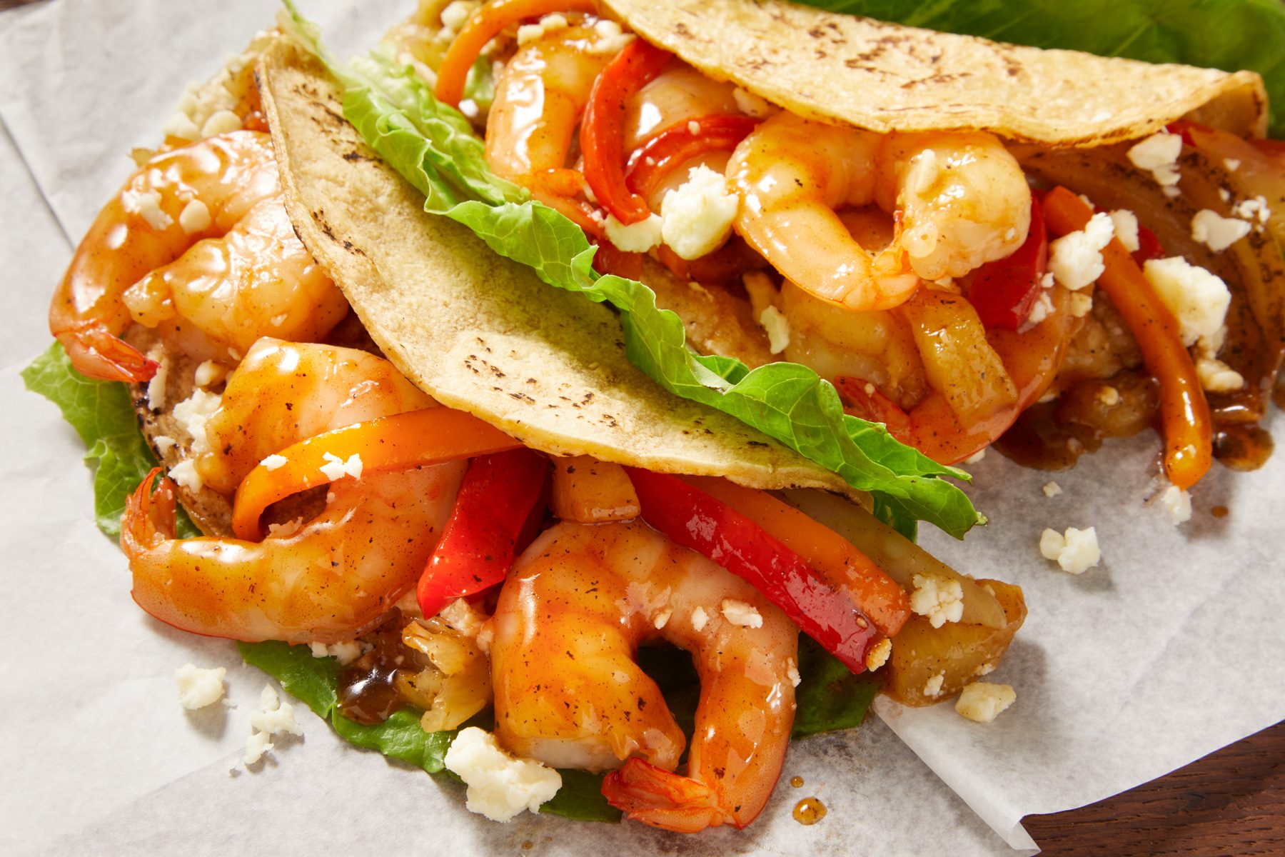 closeup shot of Pineapple Shrimp Tacos placed on parchment paper