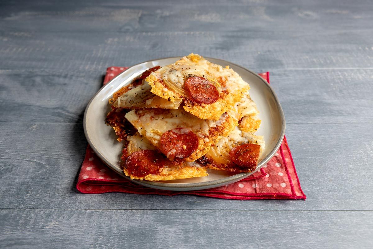 Plate of sliced onion "pizza" on top of a red napkin and a gray table
