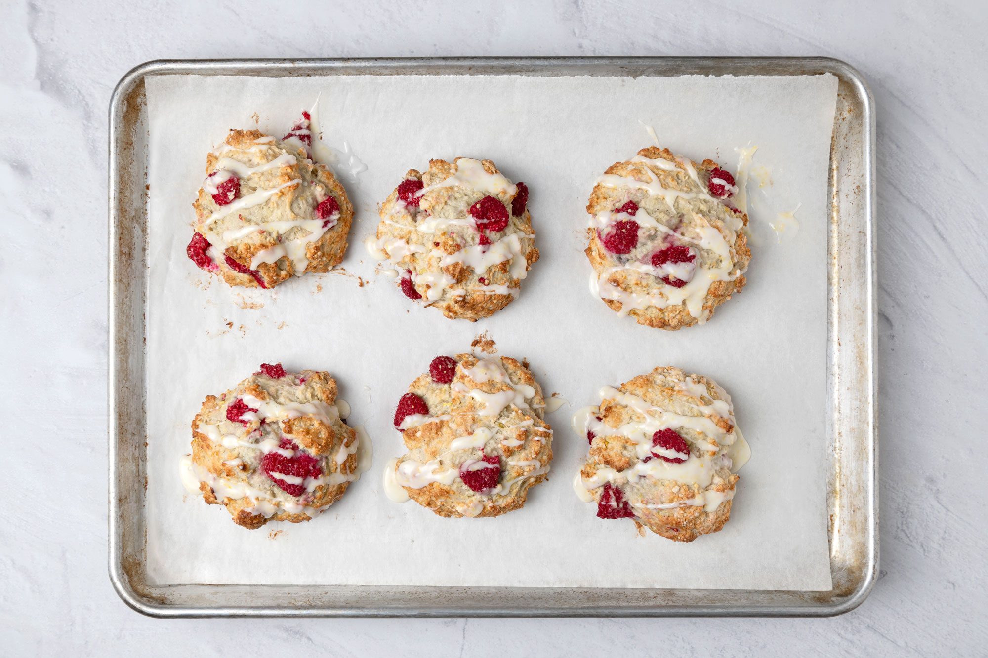 Overhead shot of baking sheet; Combine glaze ingredients; drizzle over warm scones; marble surface