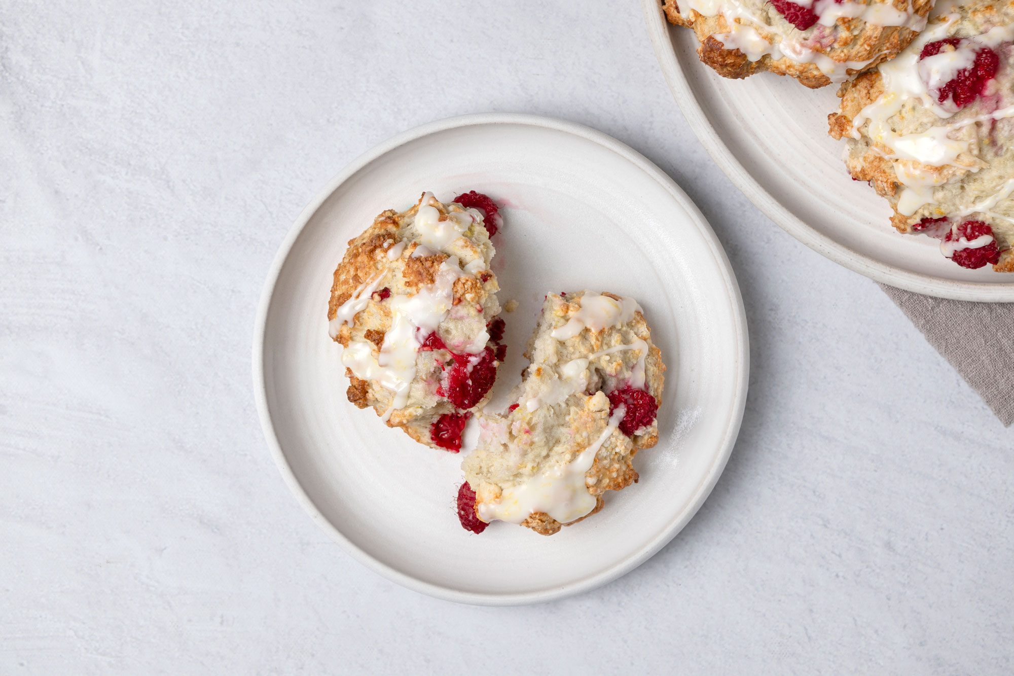 Top view shot of Raspberry Drop Scones; served on two round plates; on marble surface;