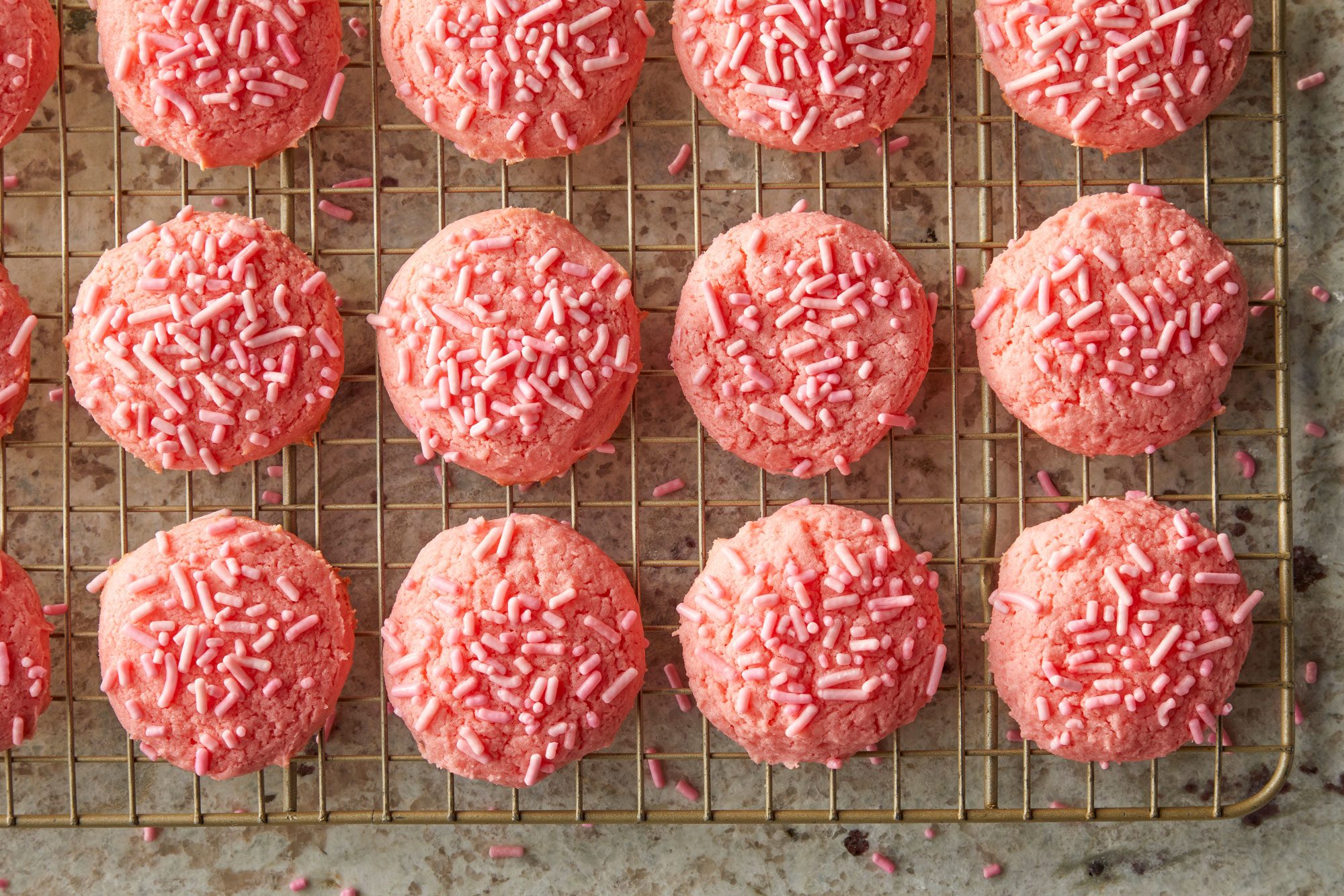Overhead shot of remove baked cookies to wire racks to cool completely; Store in an airtight container; all arranged on a marble surface