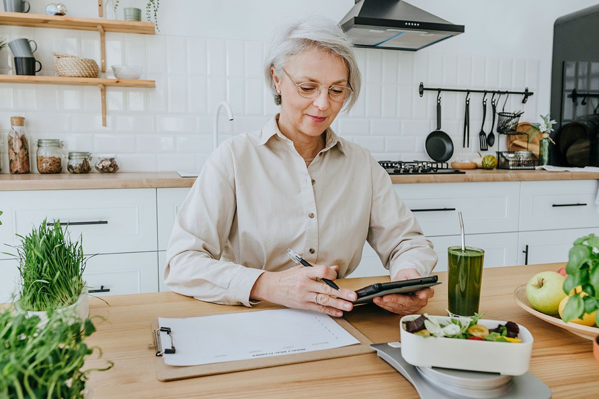 Mature woman with tablet PC in kitchen at home