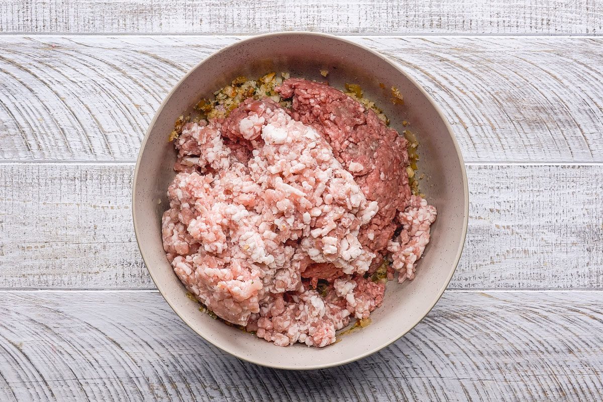 Crumble beef and pork over the mixture and mix well