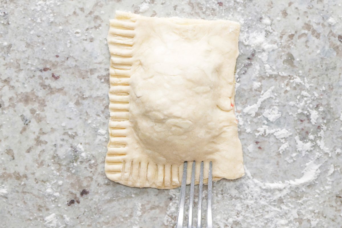 Pressing the edges together with a fork’s tines to seal