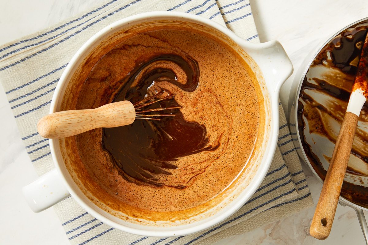chocolate mixture added to eggs in a large bowl