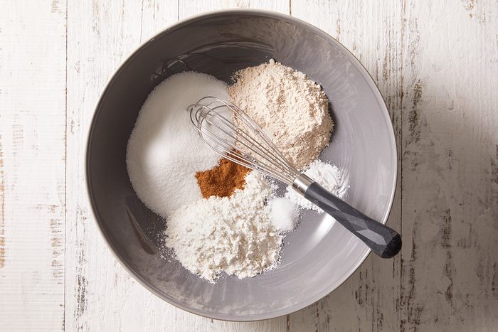 In a large bowl, combine the sugar, flours, baking powder, salt and cinnamon.